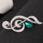 Broche Belons tendance en forme de note de musique/clé de sol avec strass et cristal vert en forme de goutte, pour femme